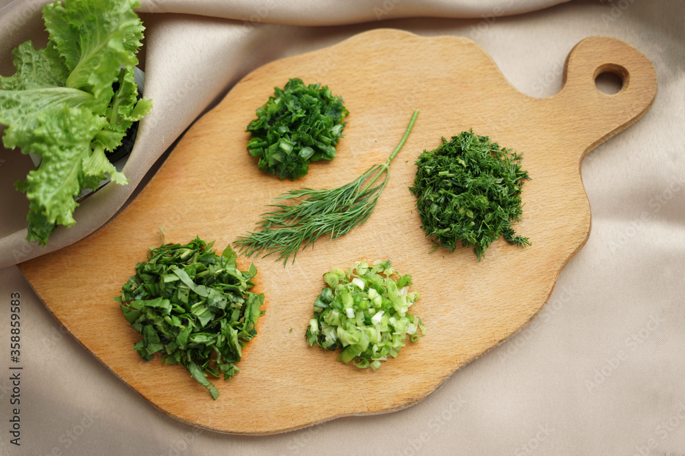 Green ingredients prepared for cooking on a wooden chopping board, flatlay Green ingredients prepared for cooking on a wooden chopping board, flatlay