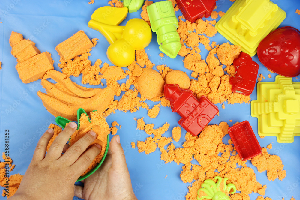 Obraz premium Kinetic sand. Child building sandcastle various figures