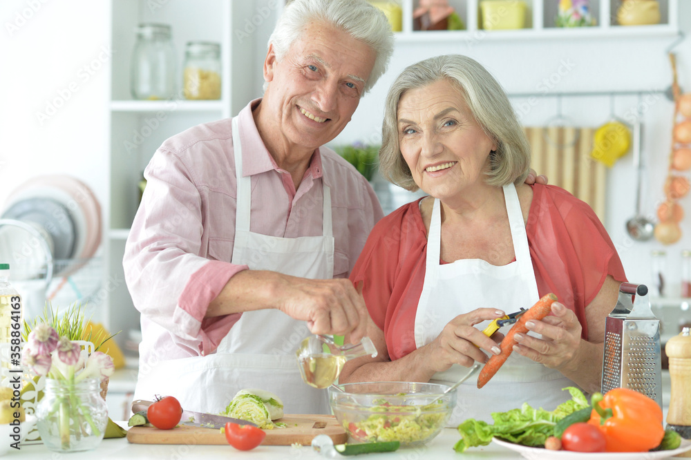 Portrait of senior couple cooking together at kitchen Portrait of senior couple cooking together at kitchen