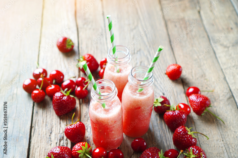 Glass bottles with a red smoothies made with red berries and fruits. Summer beverage background. Glass bottles with a red smoothies made with red berries and fruits. Summer beverage background.