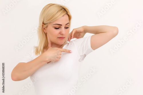 woman shows a spot on her white t-shirt