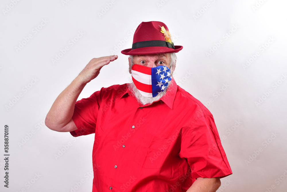 Old veteran wearing a patriotic mask giving the hand salute..Respectful man wearing a patriotic face mask salutes all the health care workers. Old veteran wearing a patriotic mask giving the hand salute..Respectful man wearing a patriotic face mask salutes all the health care workers.
