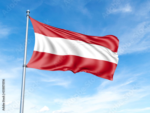 Austria flag on a pole against a blue sky background.