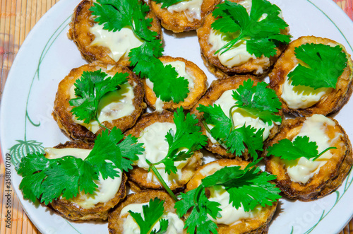  Sliced ​​fried zucchini with mayonnaise and parsley.