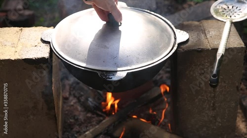 cooking Uzbek pilaf in a cauldron on fire in nature during a hike, national food, hiking food, nobody photo