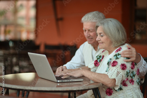 Portrait of happy senior couple with laptop