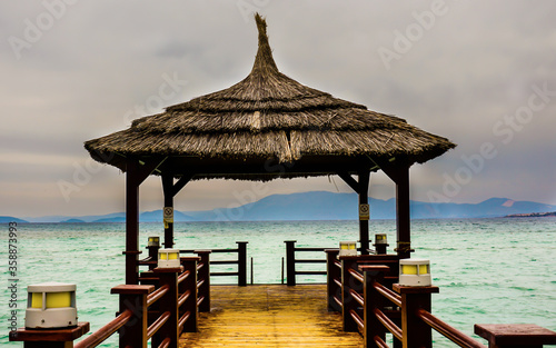 Wooden pier on Aegean Sea. A long coast pier under the sky. A quite  peaceful and calm holiday resort place in Cesme  Izmir Turkey. Path goes   leads to sea   freedom.