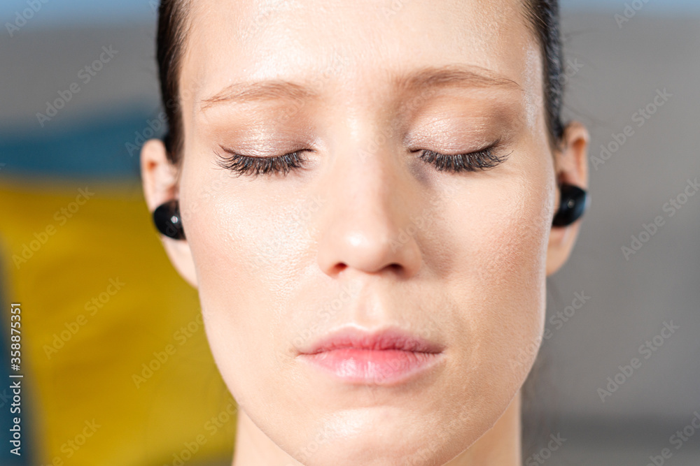 Close up portrait of attractive relaxed young woman meditating at home. Girl with eyes closed. Close up portrait of attractive relaxed young woman meditating at home. Girl with eyes closed.