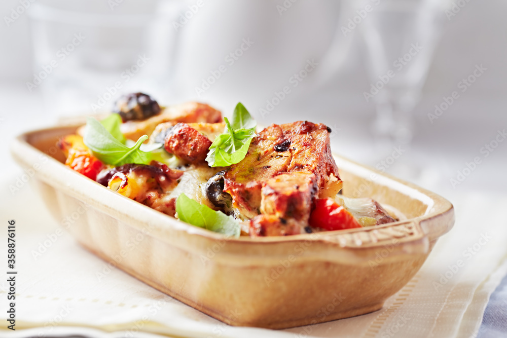 Pork tenderloin baked with Penne pasta, cherry tomatoes, black olives and cheese. Bright background. Close up Pork tenderloin baked with Penne pasta, cherry tomatoes, black olives and cheese. Bright background. Close up