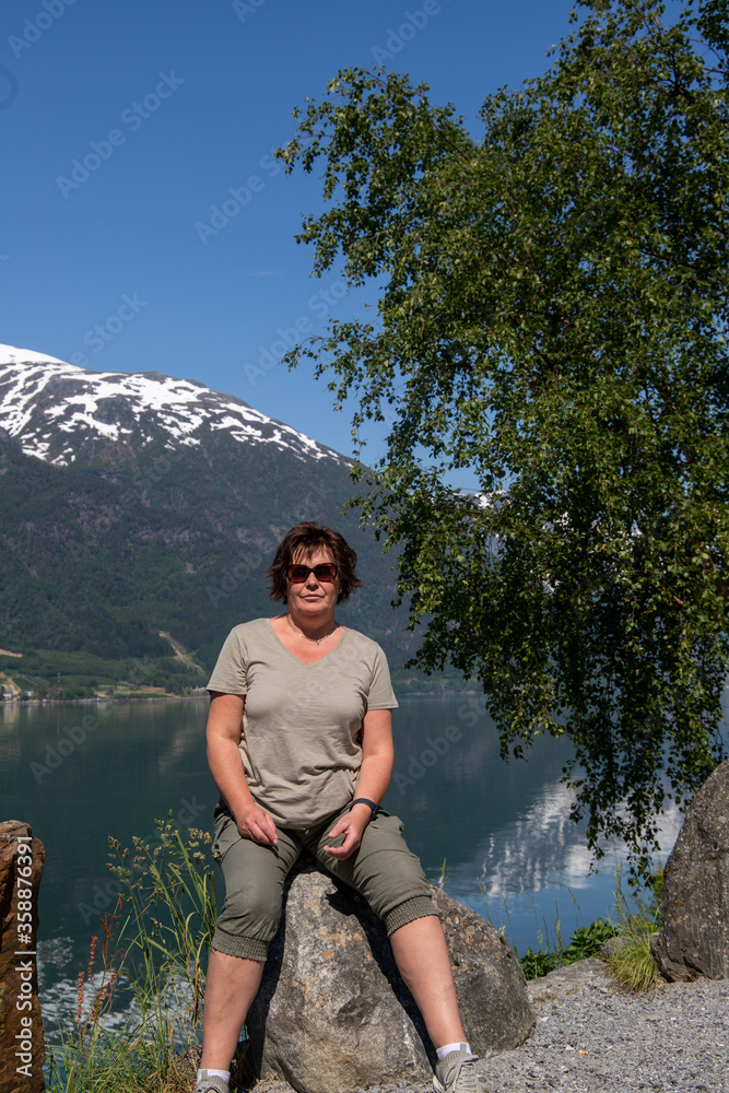 woman stands by beautiful mountains in norway