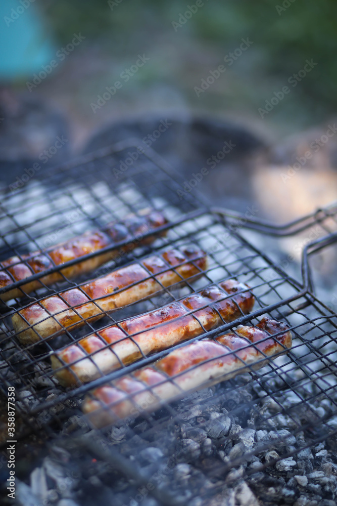 sausages are grilled on the grill, barbecue in nature