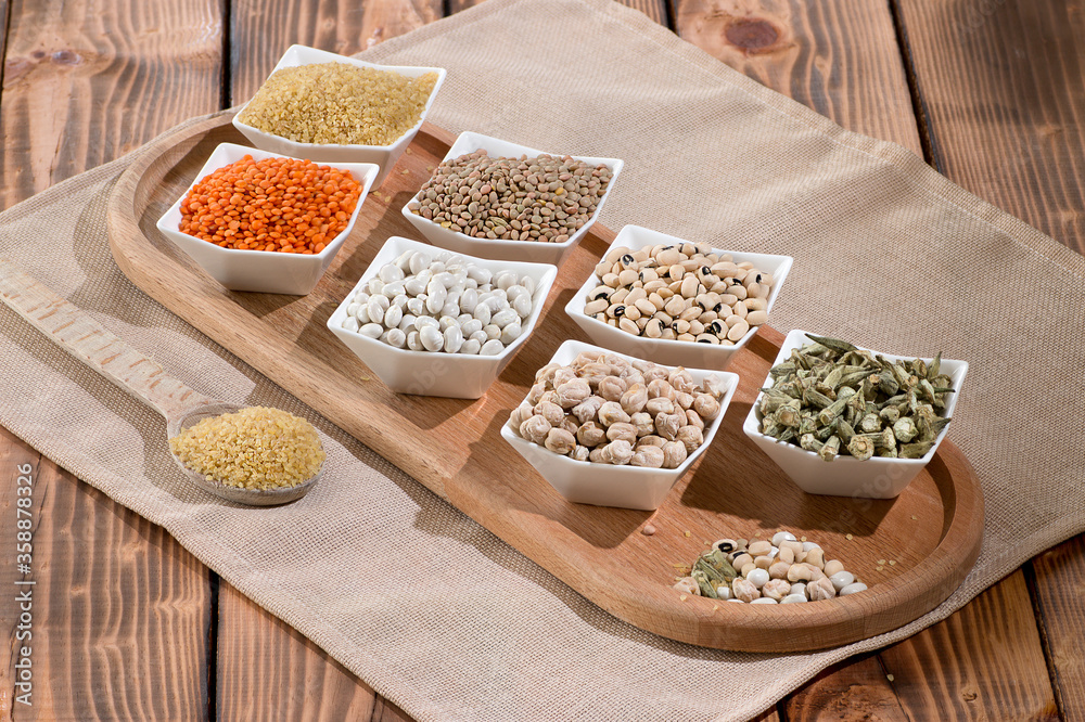 composition of different types, color and flavor dried legumes on rustic wooden background