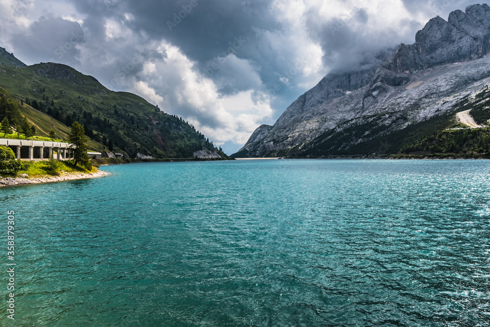 Beautiful mountain lake in Dolomites with heavy clouds on the background