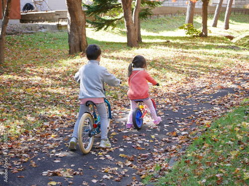 An infant boy and girl practising bicycle