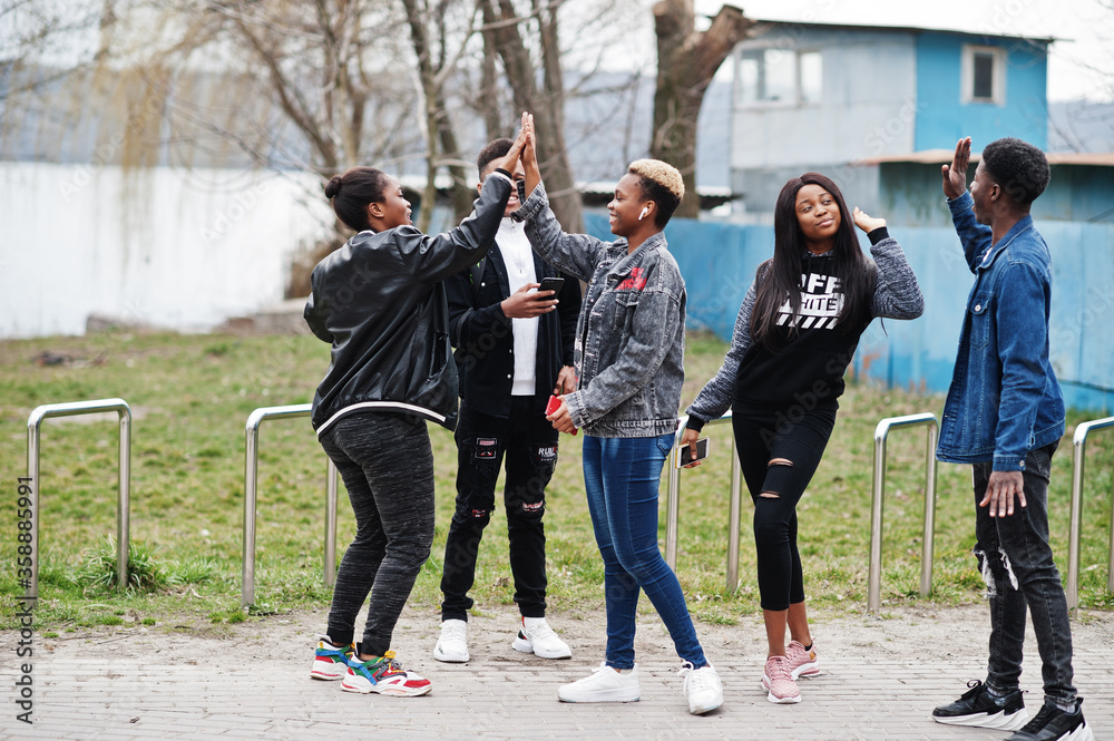 Obraz premium Young millennials african friends walking in city. Happy black people having fun together. Generation Z friendship concept.