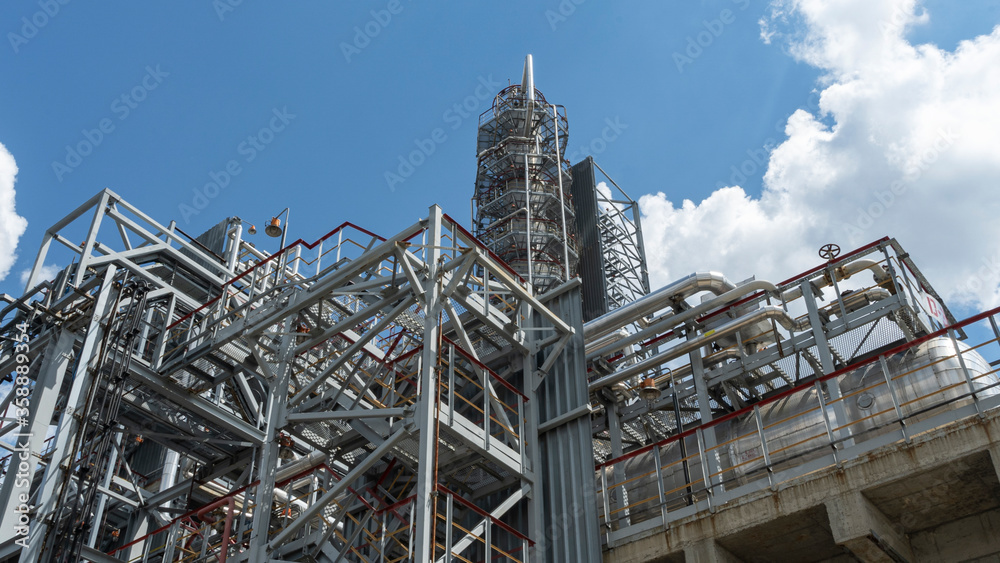 Factory on oil refining. Petrochemical industrial plant on the classic blue sky background. Space for text. Gasoline production concept. Factory on oil refining. Petrochemical industrial plant on the classic blue sky background. Space for text. Gasoline production concept.