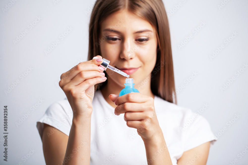 Young woman with beautiful skin puts vitamins on her face Young woman with beautiful skin puts vitamins on her face