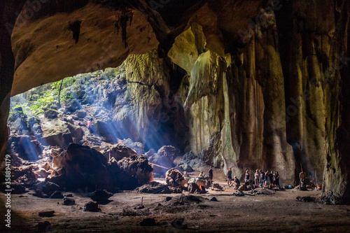 TAMAN NEGARA, MALAYSIA - MARCH 17, 2018: Tourists in a cave in the jungle of Taman Negara national park. photo