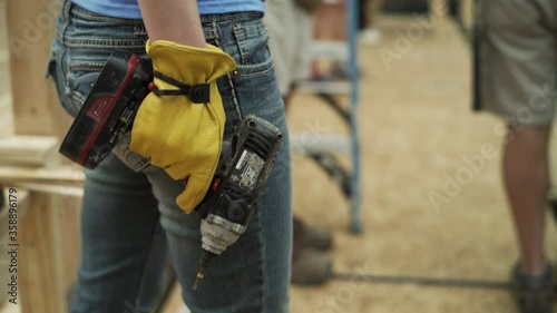 Female Construction Worker Holds a Power Drill on Construction Site photo