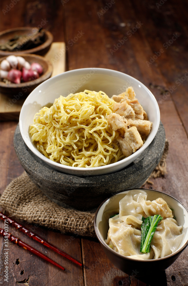 Chicken noodles and boiled dumplings. A bowl of boiled noodles is given a spice of broth and a sprinkling of chicken pieces. Plus a bowl of boiled dumplings. Isolated on Asian Food. Chicken noodles and boiled dumplings. A bowl of boiled noodles is given a spice of broth and a sprinkling of chicken pieces. Plus a bowl of boiled dumplings. Isolated on Asian Food.