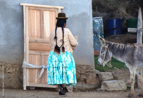 Indigenous aimara woman with donkey in the street of Yumani (Isla del Sol, Lake Titicaca, Bolivia)	 photo
