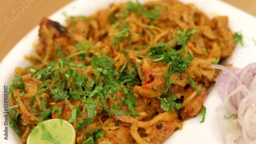 Making masala soya chaap tikka with onions and green mint chutney, served on a white plate.