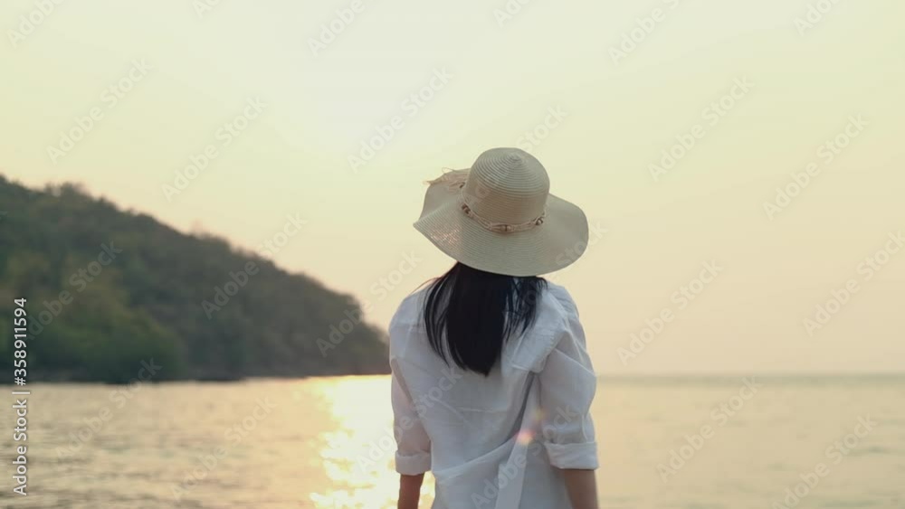 Young asian woman traveler stretching with arms raised feeling relax enjoy a holiday while standing on the beach. Young asian woman traveler stretching with arms raised feeling relax enjoy a holiday while standing on the beach.