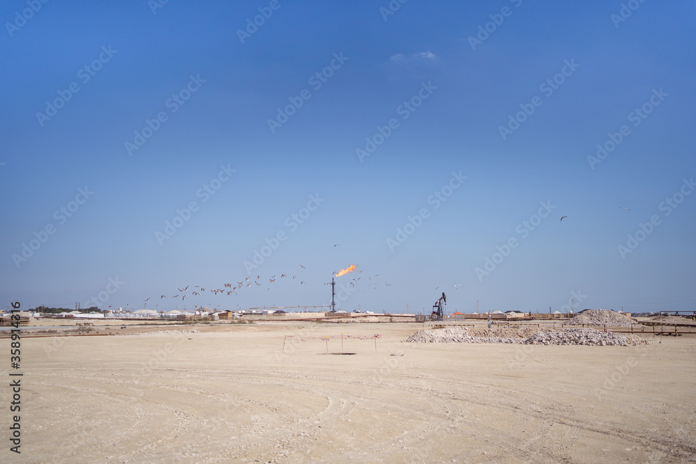 gas extraction pipeline with fire flame in oil extraction installation in the desert of Bahrain