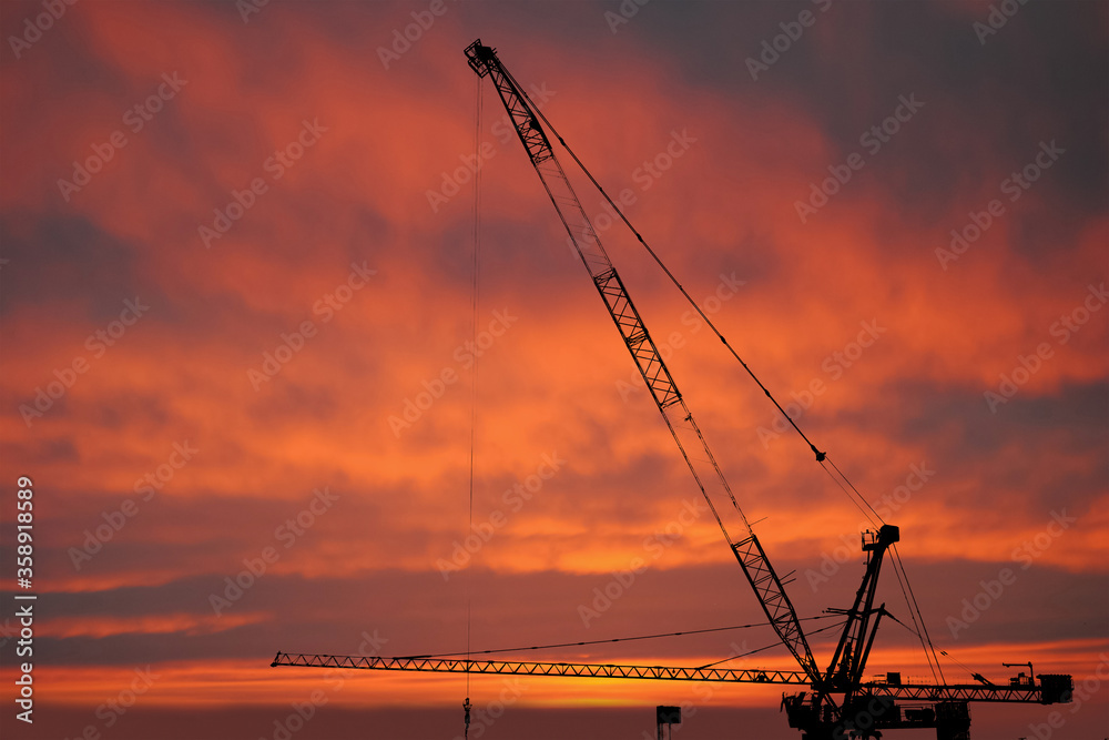 Silhouette Construction worker of Building crane on construction site background.