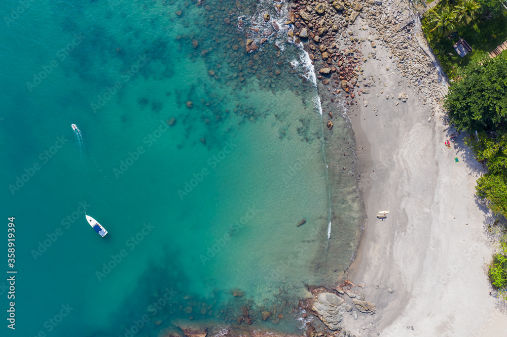 vista aérea de praia deserta em calhetas, litoral norte de são paulo, incluindo uma lancha e um jetski