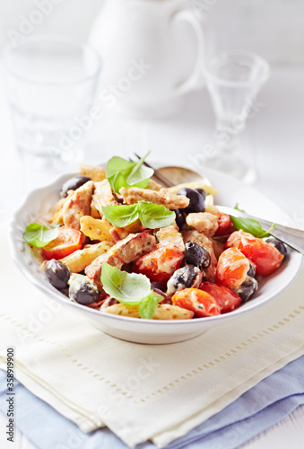 Penne pasta baked with pork tenderloin, cherry tomatoes, black olives and cheese