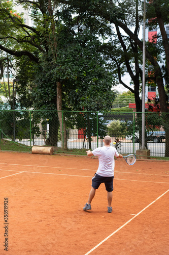 homem jogando tênis durante o dia photo