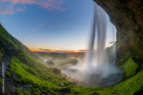 Beautiful and powerful of streaming at Seljalandsfoss waterfall from cave under waterfall in evening Summer Iceland.