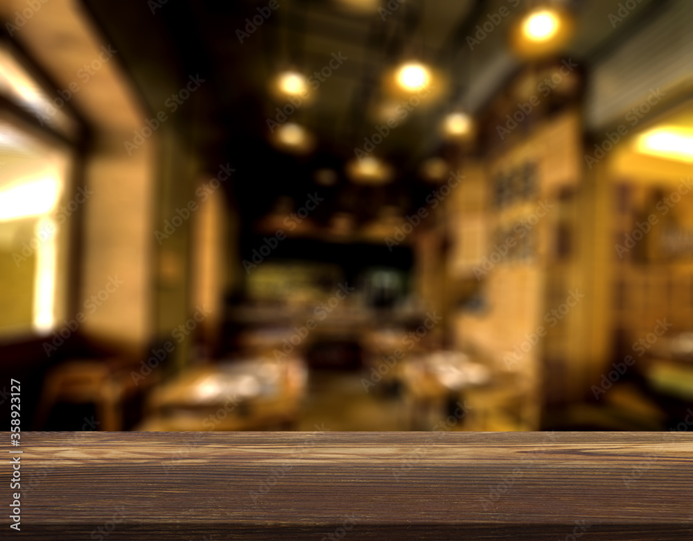 Wood table top with blur of people in coffee shop background.For ...