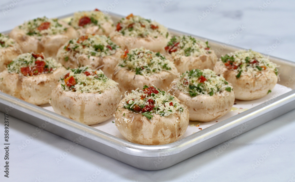 Stuffed Mushrooms on a baking sheet ready to bake with selective focus on front mushroom. Stuffed Mushrooms on a baking sheet ready to bake with selective focus on front mushroom.