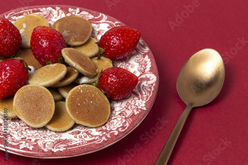 Homemade cereals mini pancake with yogurt, honey and strawberries on colorful background. photo