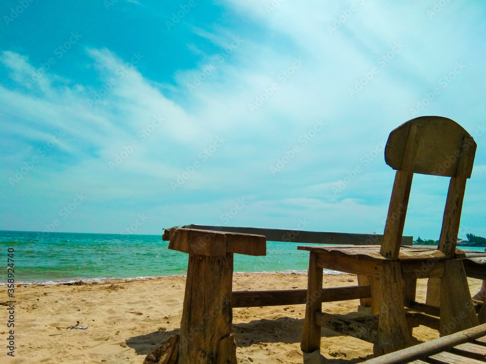 wooden chair on the beach and beautiful clouds