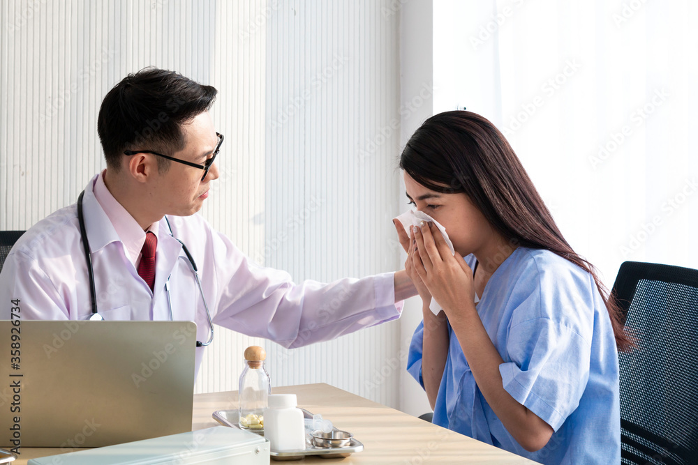 Female Patient Being Reassured by Doctor.  Young patient visiting doctor in hospital. Close up of doctor and patient sitting at the desk near the window. Male doctor working with female patient. 