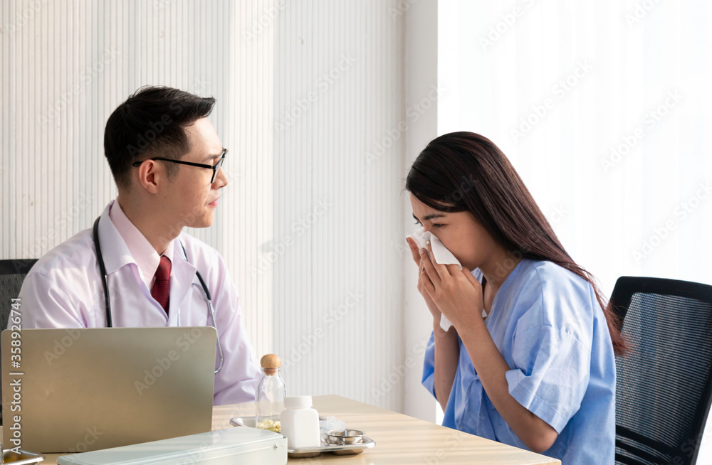 Female Patient Being Reassured by Doctor. Young patient visiting doctor in hospital. Close up of doctor and patient sitting at the desk near the window. Male doctor working with female patient. Female Patient Being Reassured by Doctor. Young patient visiting doctor in hospital. Close up of doctor and patient sitting at the desk near the window. Male doctor working with female patient.