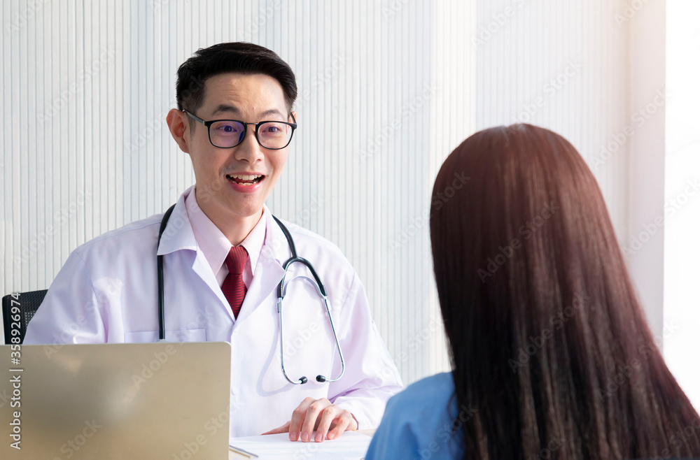 Charming male doctor giving advice to a female patient. Doctor working in the office and talking with his patient, healthcare and assistance concept. Young doctor consulting with patient. Covid-19. Charming male doctor giving advice to a female patient. Doctor working in the office and talking with his patient, healthcare and assistance concept. Young doctor consulting with patient. Covid-19.