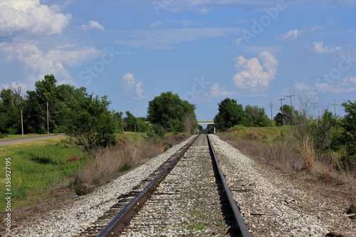 railway in the countryside in Kansas with blue sky and clouds.