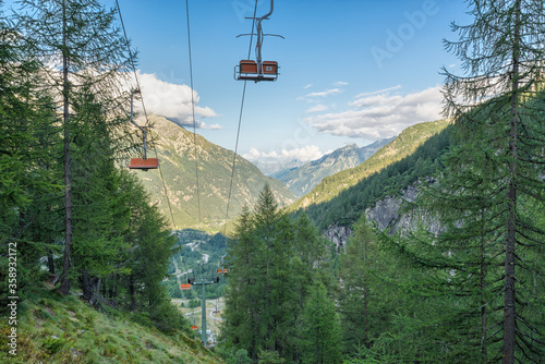 Chair lift on the european alps in summer. Vacation and hiking concept. Macugnaga and the Anzasca valley view from the Belvedere , Piedmont, Italy photo