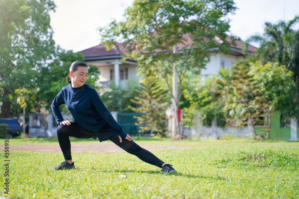 Fototapeta premium Portrait of Asian woman workout before running at village park.