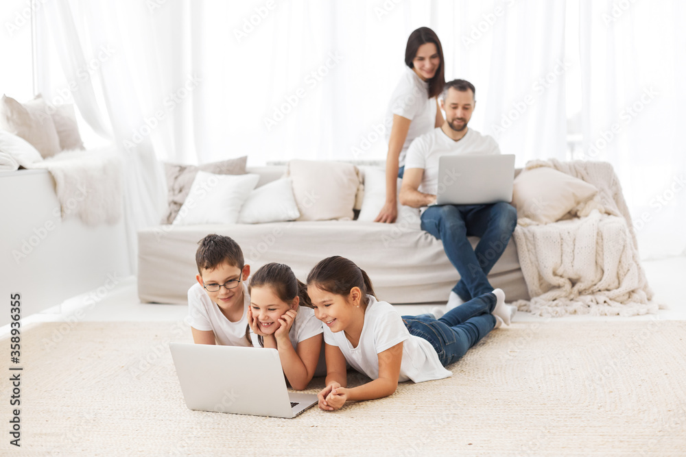 Large family with gadgets. Children and parents at home with a laptop. Large family with gadgets. Children and parents at home with a laptop.