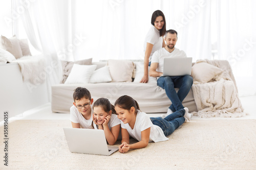 Large family with gadgets. Children and parents at home with a laptop. 