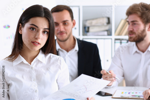 Beauty Businesswoman holding clipboard with paper fo notes on backround two peoples smiling aducation and discussing photo