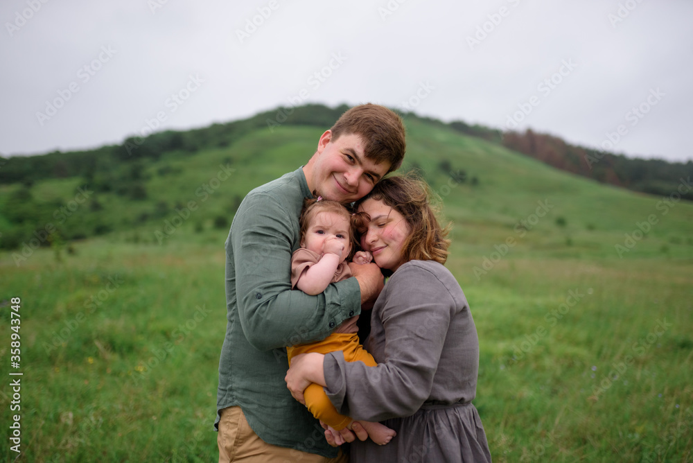 Mom, dad and daughter. Parents hug and kiss Mom, dad and daughter. Parents hug and kiss