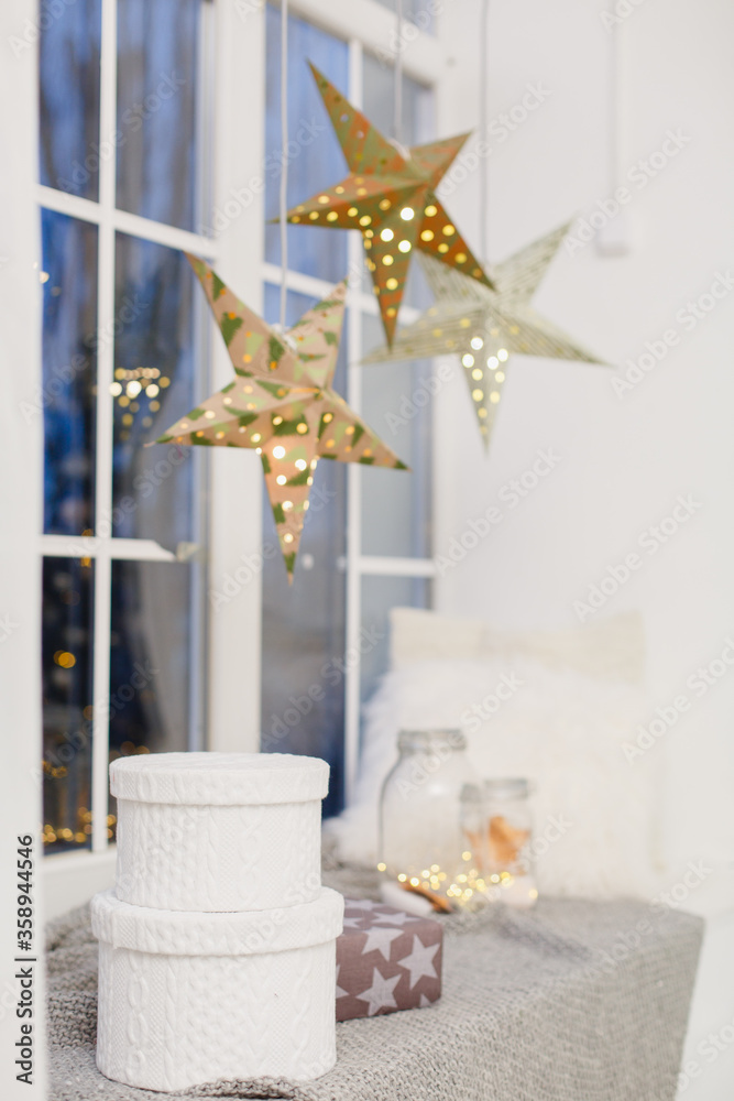 window in a room decorated for celebrating Christmas. Scandinavian interior in white colors. Gift baxes for Christmas presents