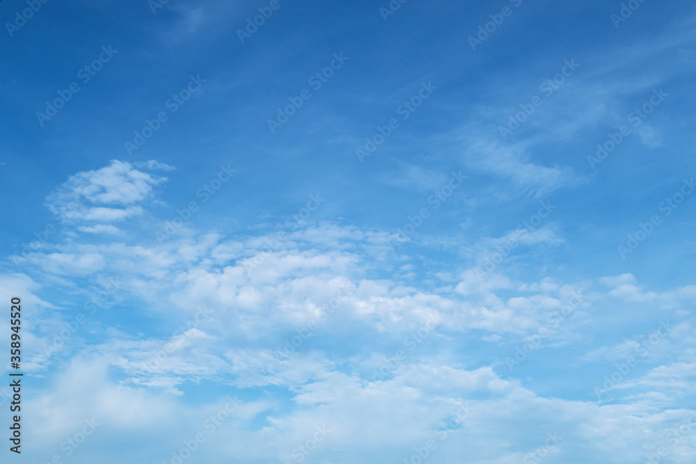 Beautiful white puffy fluffy cirrocumulus clouds & cotton candy cumulus cloudscape on beautiful sunny blue sky background in tropical summer or spring sunlight & sun rays at daylight sunshine day
