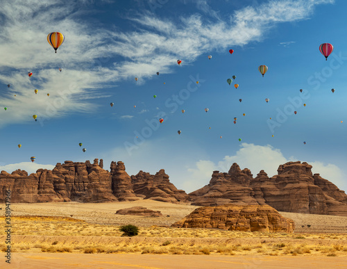 Hot air balloons behind outcrops at Mada'in Saleh archaeological site near Al Ula, Saudi Arabia